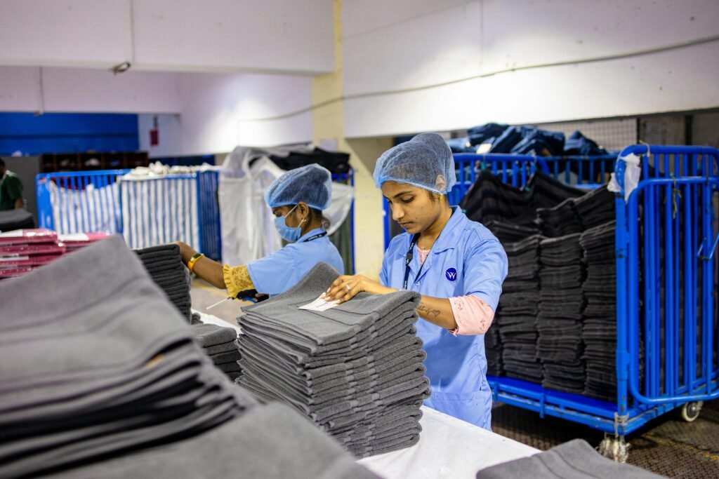 pexels-photo-31031033-31031033 Textile factory workers folding garments in an indoor environment with precise organization.