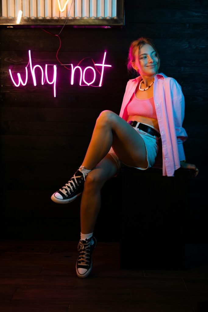 pexels-photo-9399663-9399663 Teenager in vibrant neon studio setting, expressing positivity and casual style.